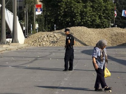 Una mujer camina junto al controvertido puente de Mitrovica.