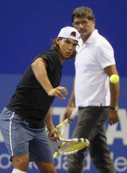 Rafael Nadal se prepara ayer en Madrid junto a su tío y entrenador, Toni.