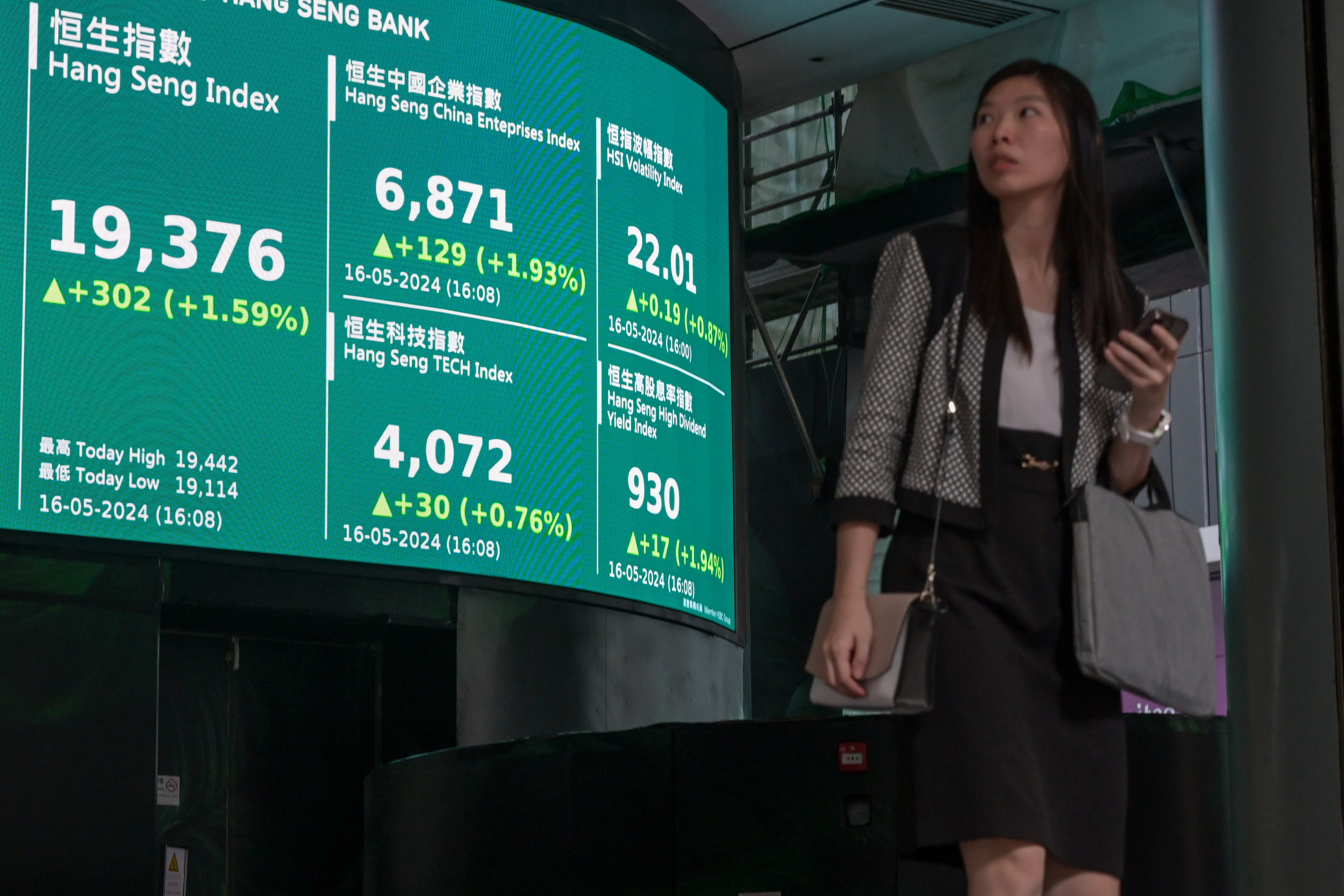 Una mujer mira las cotizaciones del índice Hang Seng en gran pantalla electrónica en Hong Kong, China.