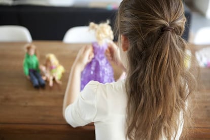 Una niña juega con una barbie.