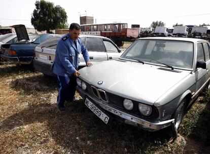 Un aduanero marroquí inspecciona algunos de los llamados "vehículos-kamikazes" recientemente incautados. Muchos de ellos llevan matrículas de Melilla. Esos coches son manipulados para poder transportar hasta 1.500 litros de gasolina. Procedentes de Argelia entran en Marruecos con su carburante de contrabando y circulando a tumba abierta por caminos secundarios para tratar de sortear los controles de la aduana.