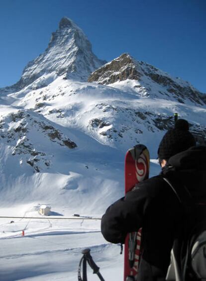 Una esquiadora contempla el Matterhorn desde una estación de telecabina en Scwarzsee paradise, Zermatt