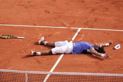 Nadal celebra su victoria revolcándose en la tierra de la pista tras vencer al <i>número uno</i> del mundo.