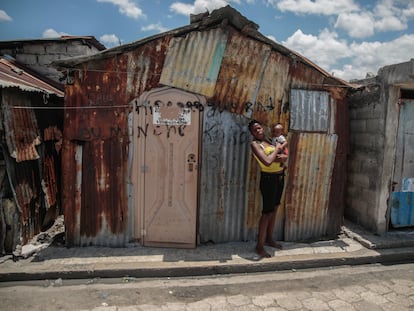 Un mujer carga a su bebé afuera de su vivienda en Puerto Príncipe (Haití), en abril de 2023.