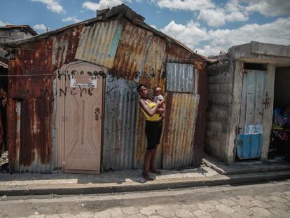 Un mujer carga a su bebé afuera de su vivienda en Puerto Príncipe (Haití), en abril de 2023.