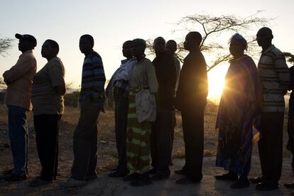 Un grupo de personas hacen cola para poder votar en una escuela primaria en el norte de Kenia. A primera hora de la jornada electoral, la tensión que protagoniza estos comicios, que se celebran 5 años después de la oleada de violencia postelectoral que se cobró unas 1.300 vidas ya se había cobrado 17 vidas.