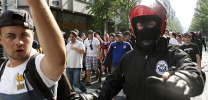 Agentes de la Ertzaintza escoltan a aficionados del Olympique en San Sebastián. 