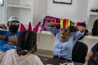 María (a la derecha), 16 años, se pone una máscara como parte de una actividad en el Albergue Temporal para Niñas y Adolescentes Migrantes. Separados o No Acompañados en Tapachula, cuando llegó al albergue, los primeros sentimientos de María fueron de tristeza. El refugio no era su destino deseado. Y la ruta que la trajo allí estaba llena de dolores. En noviembre de 2020, el huracán Eta arrasó su natal Honduras y mató a sus padres. Ahora huérfana, decidió salir de casa en busca de familia en Estados Unidos. Las esperanzas de María se detuvieron cuando fue detenida por funcionarios de inmigración cerca de la frontera entre Guatemala y México y trasladada al Albergue Temporal para Niñas y Adolescentes Migrantes Separados o No Acompañados, un refugio temporal para niñas migrantes no acompañadas. “Experimentan estrés en tránsito al migrar de un país a otro. Estas situaciones generan estrés y ansiedad y pueden plantear desafíos para su salud mental. Sus derechos, resiliencia, autoestima y el poder de llevar sus vidas viajan con ellos”, explica Ana Cecilia Carvajal, quien monitorea el apoyo psicosocial que llevan a cabo los socios de Unicef sobre el terreno. "Queremos brindarles apoyo y recordarles su valor y ayudarlos a pensar de manera positiva".