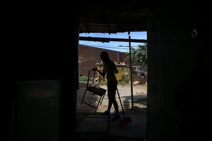 Pilar, ama de casa, limpia su hogar construido cerca de la valla fronteriza que separa Estados Unidos y México, en Tijuana (México).