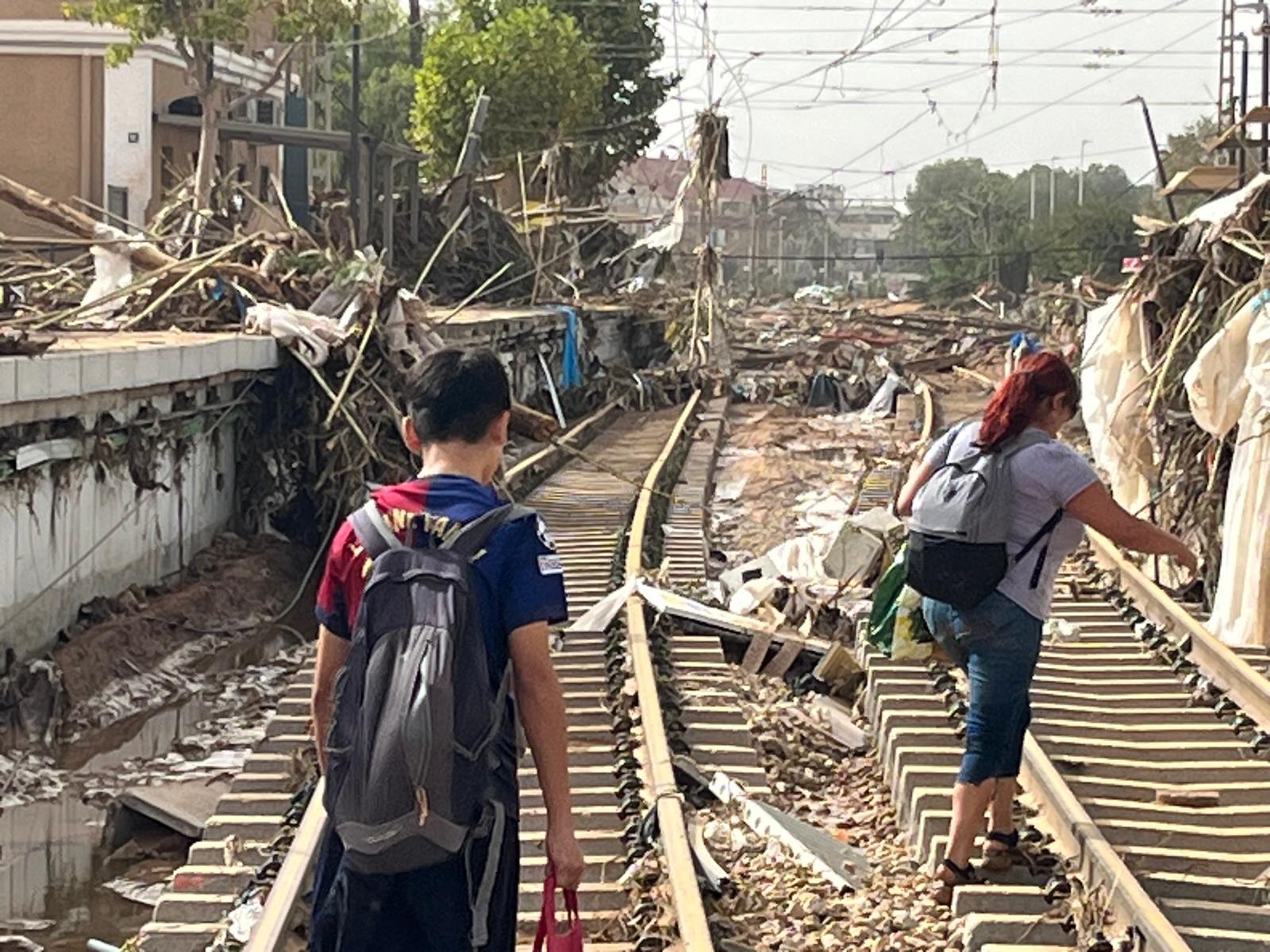 Una madre y su hijo, caminan por las vías destrozadas del Metro de Paiporta.