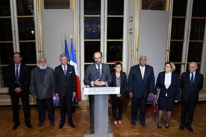 El primer ministro francés, Edouard Philippe (c), flanqueado por representantes de Nueva Caledonia, en París, el jueves