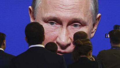 Asistentes del Foro Econ&oacute;mico Internacional de San Petersburgo el 2 de junio frente a una pantalla donde aparece el presidente de Rusia, Vlad&iacute;mir Putin. 