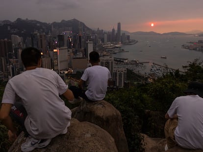Mainland Chinese tourists look at sunset from a hill in Hong Kong, April 26, 2023.