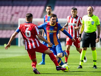 Messi, capitán del Barcelona, intenta regatear a Koke, capitán del Atlético de Madrid, durante un partido entre los dos equipos.