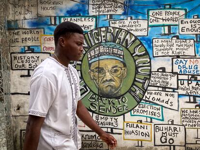 Un hombre pasa por delante de un mural pintado para unas elecciones anteriores en el que aparece el actual presidente, Muhammadu Buhari, en Lagos, Nigeria, el viernes 24 de febrero de 2023.