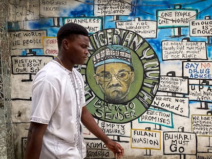 Un hombre pasa por delante de un mural pintado para unas elecciones anteriores en el que aparece el actual presidente, Muhammadu Buhari, en Lagos, Nigeria, el viernes 24 de febrero de 2023.