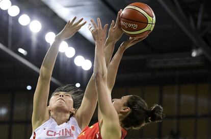 La jugadora de baloncesto de España, Alba Torrens (d), trata de anotar ante la presión de la jugadora de China, Chen Nan, durante un partido del grupo B celebrado en el Arena de la Juventud de Río de Janeiro.