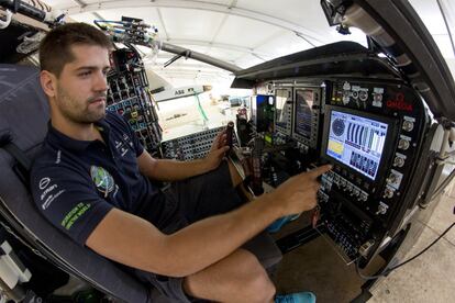 Un ingeniero toca varios botones de control en el interior de la cabina de vuelo del avión.