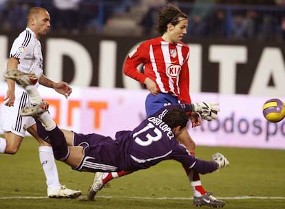 El portero madridista, Diego López despeja el balón ante el rojiblanco Ramos.