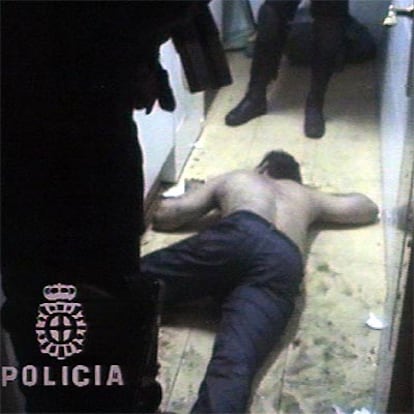 Uno de los detenidos, tumbado en el suelo, tras la entrada de los policías.