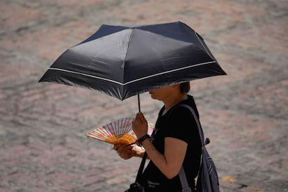 Una mujer se protege del sol con un paraguas, este domingo en el exterior de la Mezquita de Córdoba.