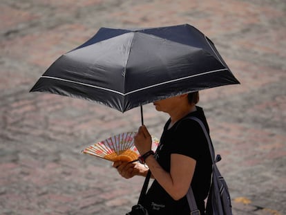 Una mujer se protege del sol con un paraguas, este domingo en el exterior de la Mezquita de Córdoba.