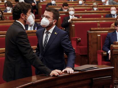 El 'president' en funciones, Pere Aragonès, a la derecha, conversa con el titular de Territorio, Damià Calvet, antes de comenzar el pleno del Parlament.