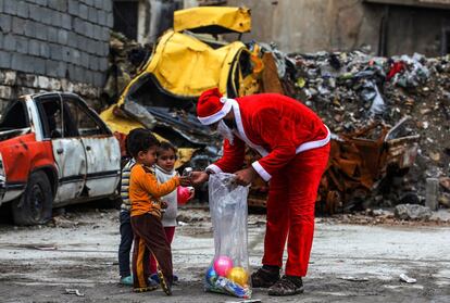 Papá Noel reparte regalos a tres niños iraquíes, en Mosul. 