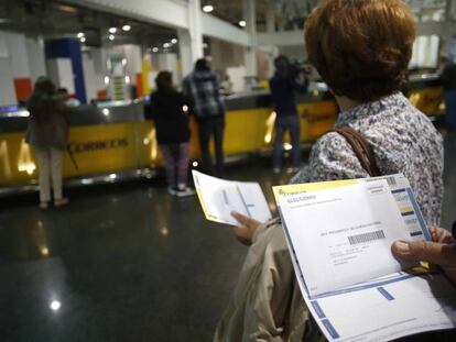 Usuarios hacen cola en una oficina de Correos.