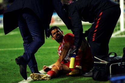 El delantero del Atlético de Madrid, Diego Costa, es atendido en la banda tras un golpe durante el partido.