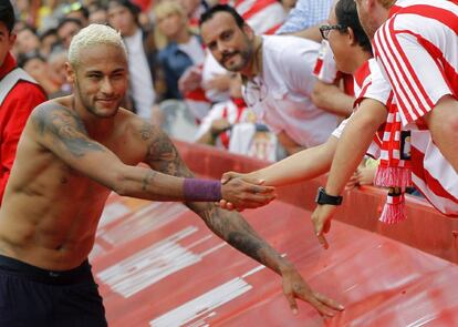 El delantero brasileño del FC Barcelona Neymar (i), autor de dos goles de su equipo frente al Sporting de Gijón, regala su camiseta a un niño, al finalizar el partido.