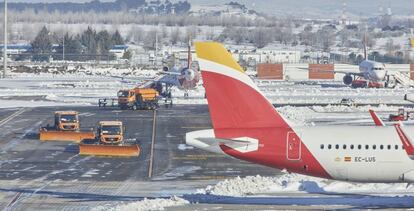 Varias excavadoras trabajan para retirar la nieve y el hielo de la pista del aeropuerto Madrid-Barajas Adolfo Suárez, en Madrid.