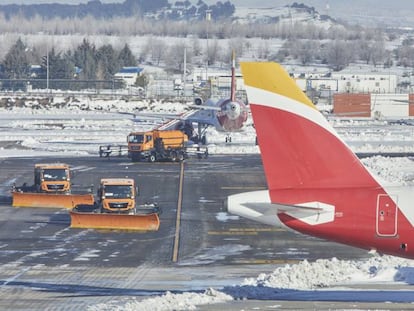 Varias excavadoras trabajan para retirar la nieve y el hielo de la pista del aeropuerto Madrid-Barajas Adolfo Suárez, en Madrid.