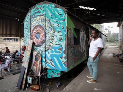 Varios artistas del colectivo BSQ trabajan frente a un vagón de tren abandonado y convertido en estudio de arte en el centro de Nairobi, Kenia, el 20 de agosto de 2019.