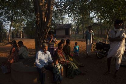 Pacientes y familiares descansan junto a un árbol y varias habitaciones del hospital de SEARCH en Shodhgram.