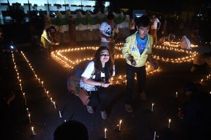 Jovenes paquistaníes encienden velas antes del inicio de la Hora del Planeta frente al edificio del parlamento en Islamabad.