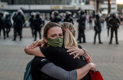 Dos jóvenes abrazadas frente a un cordón policial, durante las protestas del lunes.