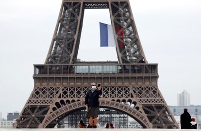 Una monja con mascarilla se hace un selfi con su teléfono móvil en la plaza del Trocadero, junto a la Torre Eiffel, este lunes en París.