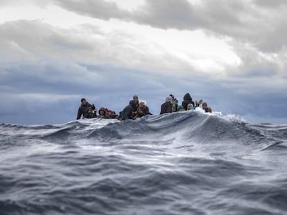 Inmigrantes provinientes de Marruecos y Bangladesh reaccionan ante la llegada de los trabajadores humanitarios de la ONG española 'Open Arms' en el mar Mediterráneo frente la costa libia, este viernes.