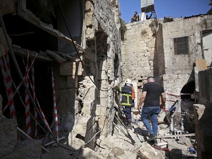 Una persona busca supervivientes en una vivienda de Gaza atacada por Israel donde murieron tres personas.