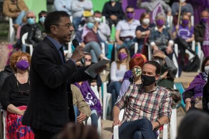 Juan Carlos Monedero participa en un mitin de Podemos en 2021, con Pablo iglesias sentado cerca de él.