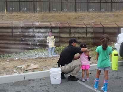 Duas crianças disparam pintura numa silhueta em San Ysidro (EUA) em 2013.