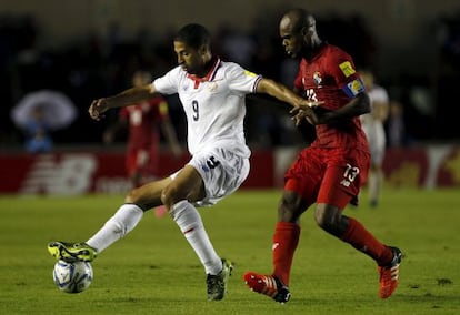 Saborio, de Costa Rica, protege el balón ante el panameño Machado.