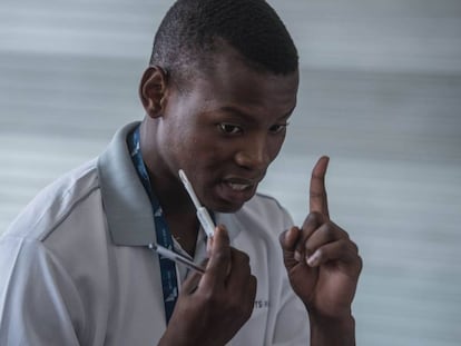 Un doctor explica a un paciente el uso del kit de autoevaluación de VIH desarrollado por estudiantes de la Universidad de Witwatersrand en Hillbrow, Johannesburgo, el 19 de marzo de 2018. 