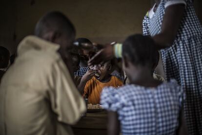 Un niño come en el comedor escolar de Bodouakro.