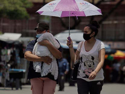 Dos mujeres se protegen de los rayos del sol con una sombrilla, en el centro de Ciudad de México.