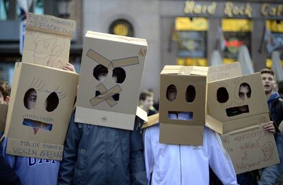 Manifestantes con una caja en la cabeza participan en la manifestación contra la política educativa del Gobierno.