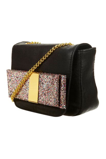 Bolso bandolera con cadena y lazo glitter, de Topshop (28 euros aprox.) para completar un look de fiesta. 