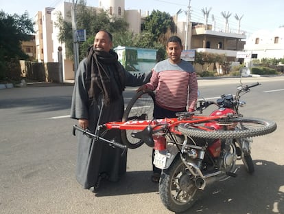 Transportando una bici en moto frente al hotel New Mennon de Luxor.