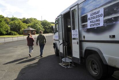 Una pareja abandona un centro de votación móvil en el pueblo de Trecw, en Gales.